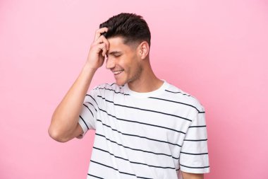 Pembe arka planda izole edilmiş genç beyaz adam gülüyor.