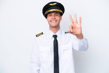 Beyaz arka planda izole edilmiş Kafkasyalı pilot mutlu ve parmaklarıyla üçe kadar sayıyor.