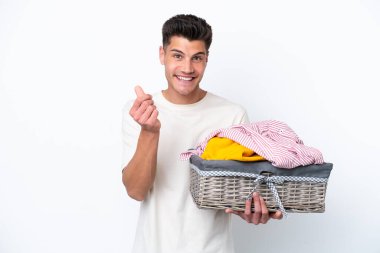Beyaz arka planda çamaşır sepeti tutan beyaz bir adam para hareketi yapıyor.