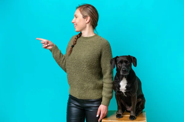 Young Caucasian Woman Her Dog Isolated Blue Background Pointing Side — Zdjęcie stockowe