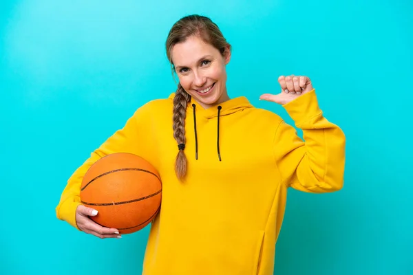 Jonge Kaukasische Vrouw Geïsoleerd Blauwe Achtergrond Spelen Basketbal Trots Zichzelf — Stockfoto