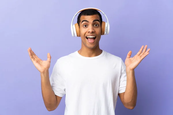 African American Man Isolated Purple Background Surprised Listening Music — Stockfoto