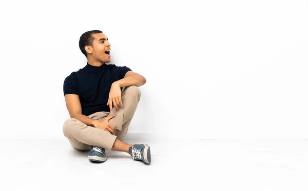 Afroamerikaner Sitzt Auf Dem Boden Und Lacht Seitenlage — Stockfoto
