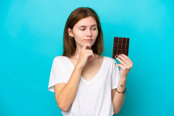 Young English Woman Chocolat Isolated Blue Background Having Doubts Thinking — Stock fotografie