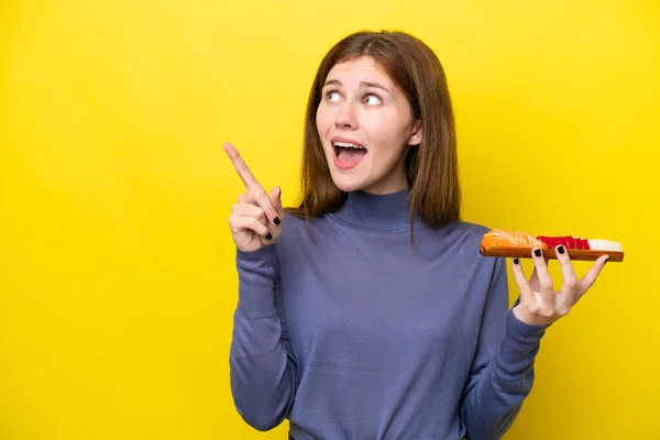 Jovem Inglesa Segurando Sashimi Isolado Fundo Amarelo Com Intenção Realizar — Fotografia de Stock