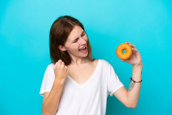 Young English Woman Holding Donut Isolated Blue Background Celebrating Victory — Stock Fotó