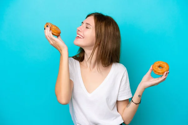 Молодая Английская Женщина Синем Фоне Держит Пончики Счастливым Выражением Лица — стоковое фото