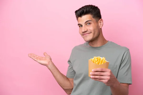 Young Caucasian Man Holding Fried Chips Isolated Pink Background Extending — Stockfoto