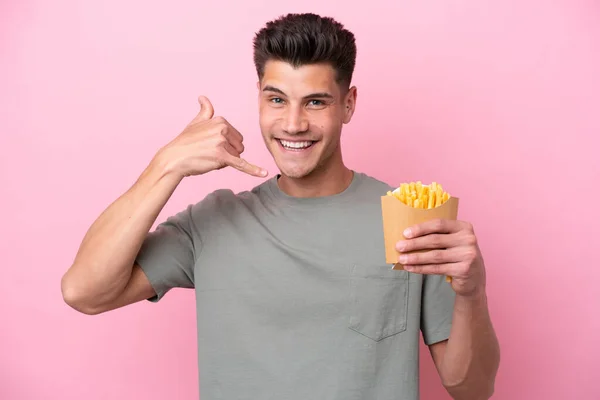 Young Caucasian Man Holding Fried Chips Isolated Pink Background Making — Stockfoto