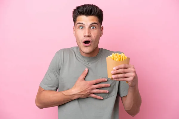 Young Caucasian Man Holding Fried Chips Isolated Pink Background Surprised — Fotografia de Stock