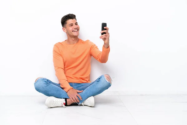 Young Man Sitting Floor Isolated White Background Making Selfie — Stockfoto