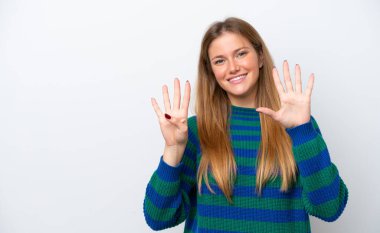 Beyaz arka planda izole edilmiş beyaz tenli genç kadın parmaklarıyla dokuz kişi sayıyor.