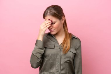 Pembe arka planda izole edilmiş, başı ağrıyan beyaz bir kadın.