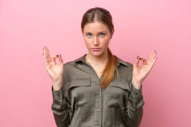 Zen pozunda pembe arka planda izole edilmiş beyaz bir kadın.