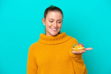 Beyaz bir kadın elinde turta tutuyordu. Mavi arka planda mutlu bir ifadeyle izole edilmişti.