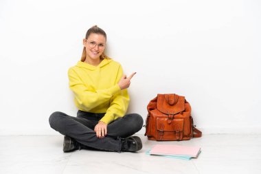 Beyaz arka planda beyaz bir zeminde oturan beyaz bir kadın.