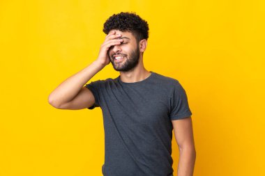 Sarı arka planda izole edilmiş genç Faslı adam çok gülümsüyor.