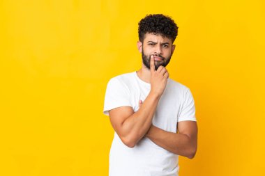 Genç Faslı bir adam sarı arka planda izole edilmiş.
