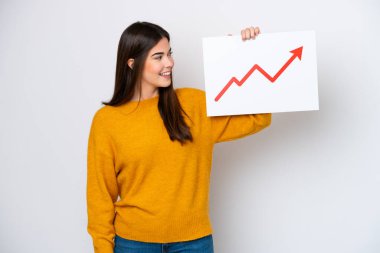 Beyaz arka planda izole edilmiş genç Brezilyalı bir kadın elinde büyüyen bir istatistik oku sembolü ve mutlu ifadeli bir tabela tutuyor.