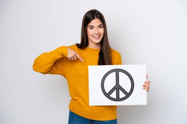 Genç Brezilyalı bir kadın beyaz arka planda izole edilmiş. Elinde barış sembolü olan bir pankart var.
