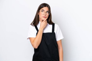 Restorandaki Brezilyalı garson kadın beyaz arka planda izole edilmiş. Şüpheleri var ve kafası karışmış bir yüz ifadesi var.