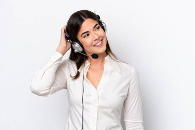 Beyaz arka planda izole edilmiş bir kulaklıkla çalışan beyaz pazarlamacı kadın bir fikir düşünüyor.