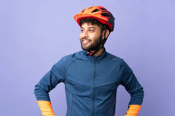 Young Moroccan Cyclist Man Isolated Purple Background Posing Arms Hip — Foto de Stock