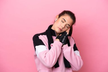 Pembe arka planda izole edilmiş Brezilyalı genç bir kadın uyku jesti yapıyor.