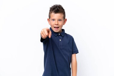 Beyaz arka planda izole edilmiş küçük beyaz çocuk şaşırmış ve ön tarafı işaret ediyor.