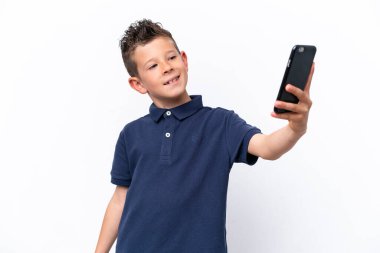 Little caucasian boy isolated on white background making a selfie
