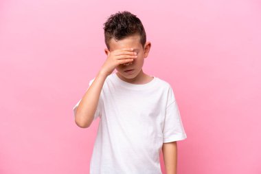 Little caucasian boy isolated on pink background with headache