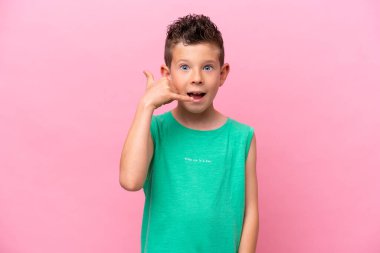 Pembe arka planda izole edilmiş küçük beyaz çocuk telefon jesti yapıyor. Bana geri dönüş işareti ver.