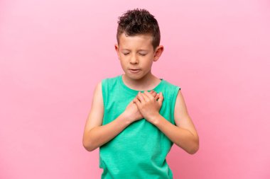 Pembe arka planda izole edilmiş küçük beyaz çocuk. Kalbinde bir ağrı var.