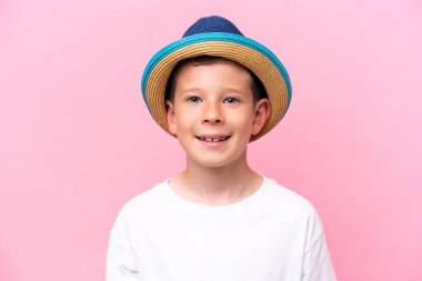 Pembe arka planda izole edilmiş şapka takan beyaz bir çocuk.