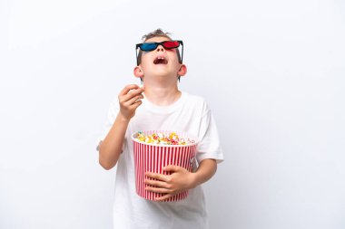 Beyaz arka planda üç boyutlu gözlüklü ve elinde koca bir kova patlamış mısır tutan beyaz tenli bir çocuk.
