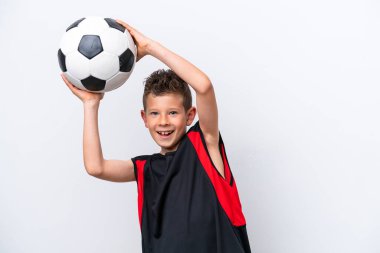İzole edilmiş beyaz duvarda futbol oynayan çocuk.