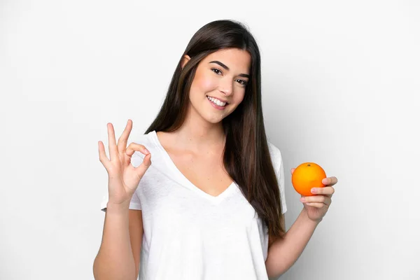 Молодая Бразильская Женщина Держит Апельсин Изолирован Белом Фоне Показывая Знак — стоковое фото