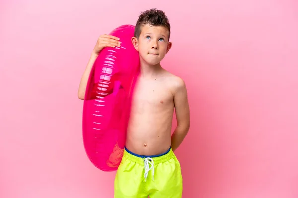 Little Caucasian Boy Holding Inflatable Donut Isolated Pink Background Looking —  Fotos de Stock
