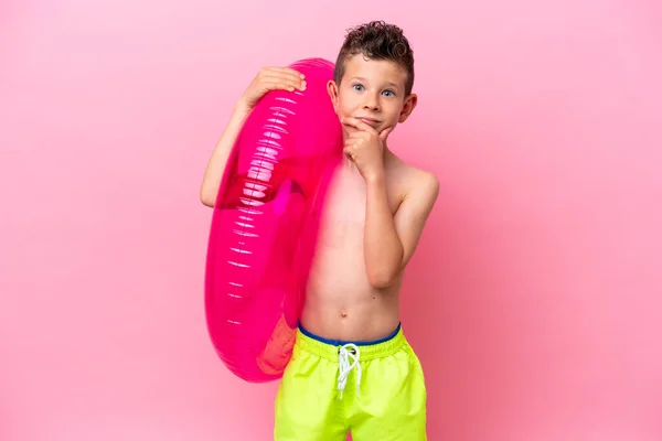 Little Caucasian Boy Holding Inflatable Donut Isolated Pink Background Thinking —  Fotos de Stock