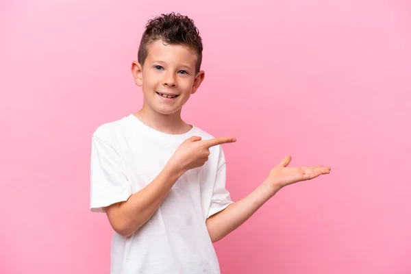 Little Caucasian Boy Isolated Pink Background Holding Copyspace Imaginary Palm — Stok fotoğraf