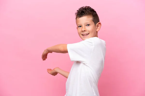 Little Caucasian Boy Isolated Pink Background Extending Hands Side Inviting —  Fotos de Stock
