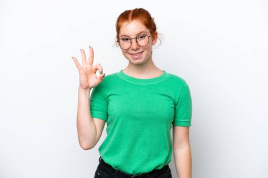 Beyaz arka planda izole edilmiş genç kızılımsı kadın parmaklarıyla işaret veriyor.
