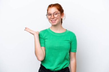 Beyaz arka planda izole edilmiş genç bir kadın, bir ilan vermek için avucunun içinde hayali bir mekan tutuyor.