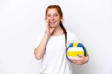 Beyaz arka planda izole bir şekilde voleybol oynayan beyaz tenli genç kadın ağzı açık bağırıyor.