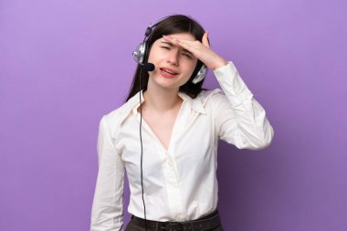 Mor arka planda izole edilmiş bir kulaklıkla çalışan pazarlamacı Rus kadın bir şeye bakmak için çok uzaklara bakıyor.