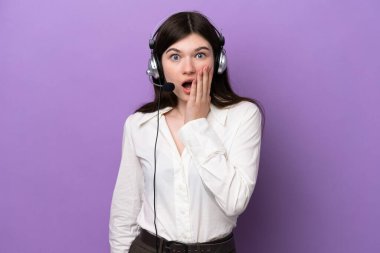 Mor arka planda izole edilmiş bir kulaklıkla çalışan pazarlamacı Rus kadın sağa bakarken şaşırmış ve şok olmuştu.