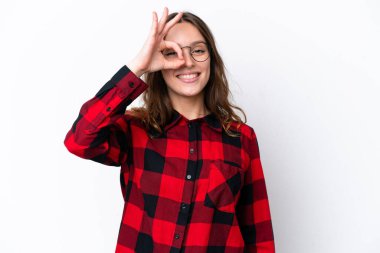 Beyaz arka planda izole edilmiş genç beyaz kadın parmaklarıyla tamam işareti gösteriyor.