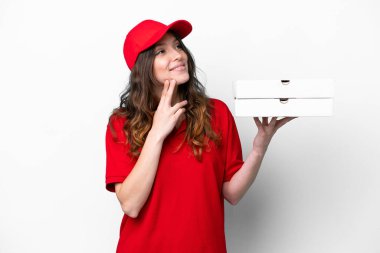 İş üniformalı pizzacı kadın beyaz arka planda izole edilmiş pizza kutularını topluyor gülümserken yukarı bakıyor
