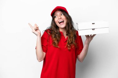 İş üniformalı bir pizzacı kadın beyaz arka planda izole edilmiş pizza kutularını topluyor. Çözümü bulmak için parmağını kaldırıyor.