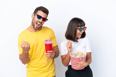 Beyaz arka planda 3 boyutlu gözlüklü ve koca bir kova patlamış mısırı tutan genç bir çift.